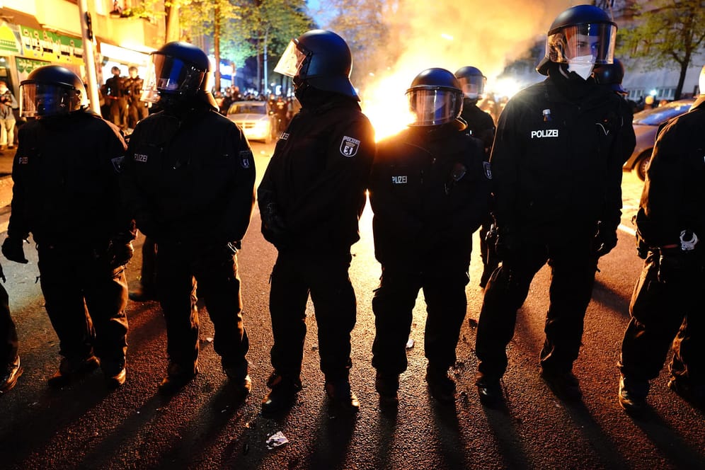 Polizisten mit Schutzhelmen stehen vor einem Brand in der Sonnenallee in Neukölln:Bei der "Demonstration zum revolutionären 1. Mai" kam es in Berlin zu Auseinandersetzungen und Randale.