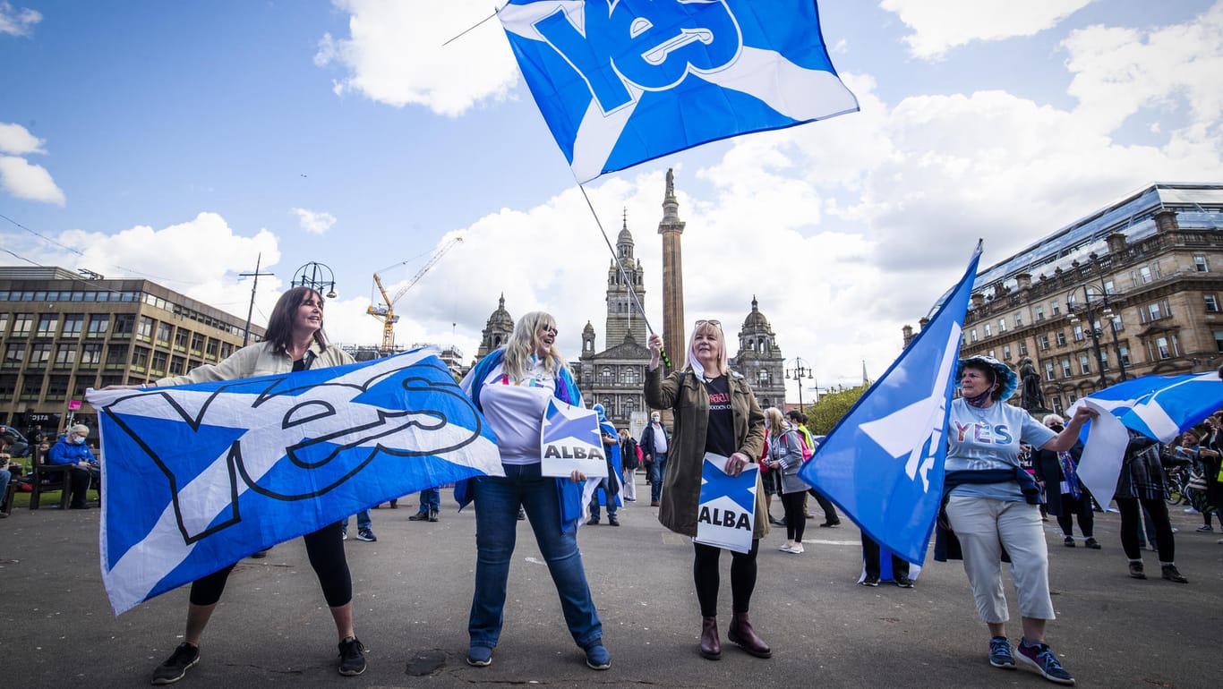 Demonstranten schwenken Fahnen während einer Kundgebung für die schottische Unabhängigkeit auf dem George Square.