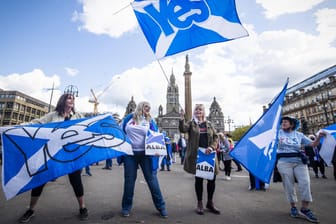 Demonstranten schwenken Fahnen während einer Kundgebung für die schottische Unabhängigkeit auf dem George Square.