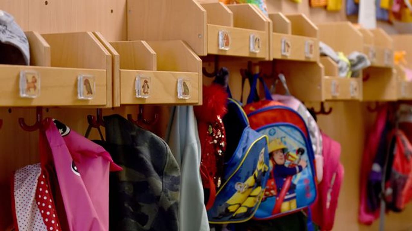 Jacken und Rucksäcke hängen in einer Städtischen Kita an Haken im Flur (Symbolbild): Viele Eltern bringen ihre Kinder trotz Notbetreuung weiter in die Kitas.