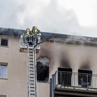 Feuerwehrleute stehen auf einer Drehleiter: In Hamburg-Jenfeld hat ein mehrstöckiges Wohnhaus gebrannt.
