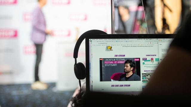 Ein Zuschauer des Festivals folgt einem Interview mit den Geschäftsführern auf der Bühne.