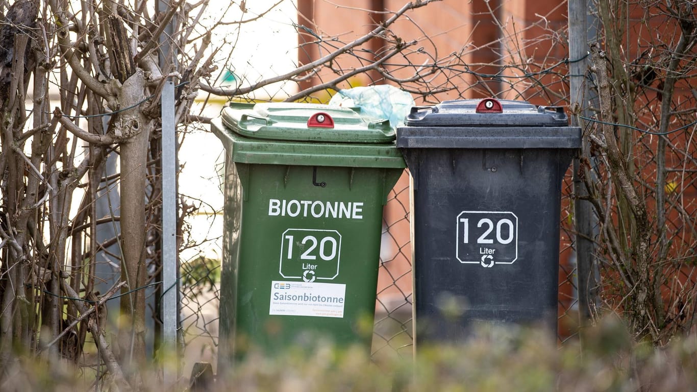 Eine Biotonne steht neben einer schwarzen Mülltonne: Auf der Flucht vor der Polizei hat sich ein Mann in einer Mülltonne versteckt.