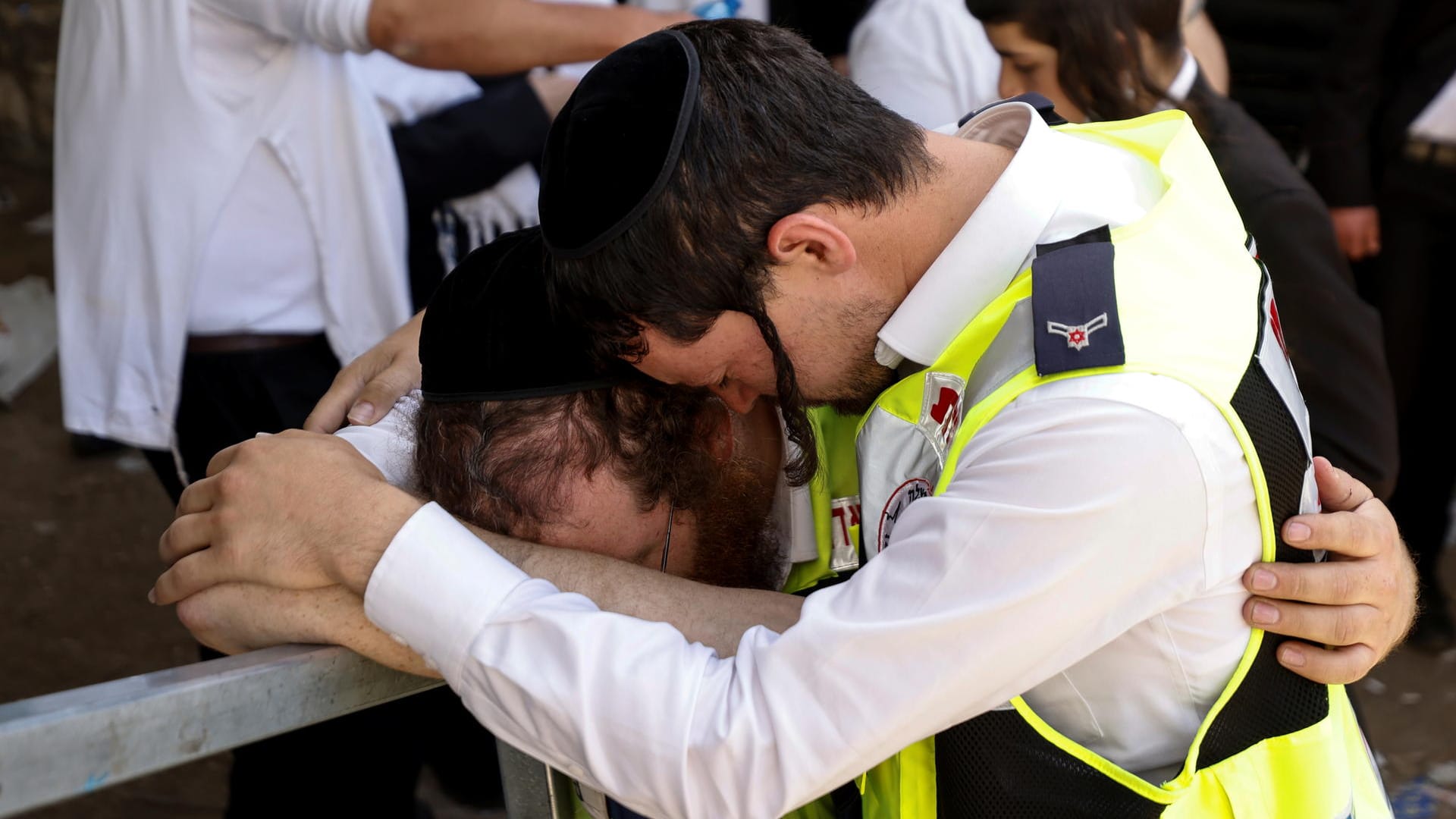 Ersthelfer trauern an der Stelle, an der Dutzende starben: Israels Flaggen wehen auf halbmast. Ersthelfer trauern an der Stelle, an der Dutzende starben: Israels Flaggen wehen auf halbmast.
