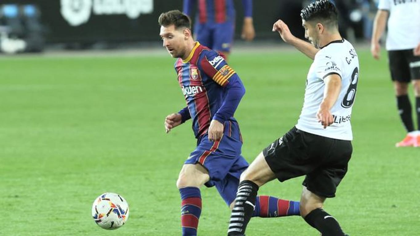 Barcelonas Lionel Messi (l) im Duell mit Valencias Carlos Soler.