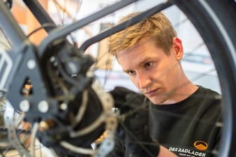 Im Februar hat er seine Ausbildung zum Zweiradmechatroniker abgeschlossen: Stefan Borschert setzt ein neues Hinterrad an einem E-Lastenrad ein.