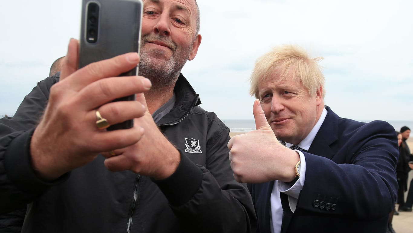 Premierminister Boris Johnson (r) macht bei einem Wahlkampftermin zur Unterstützung der Konservativen Bewerberin Mortimer im Wahlkreis Hartlepool ein Selfie mit einem Unterstützer.