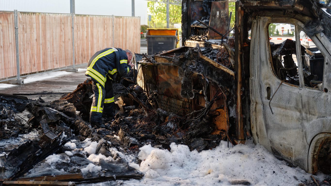 Ein Brandermittler der Polizei fotografiert die Überreste des Reibekuchenwagens: "Willi Herrens Rievkoochebud" ist abgebrannt.