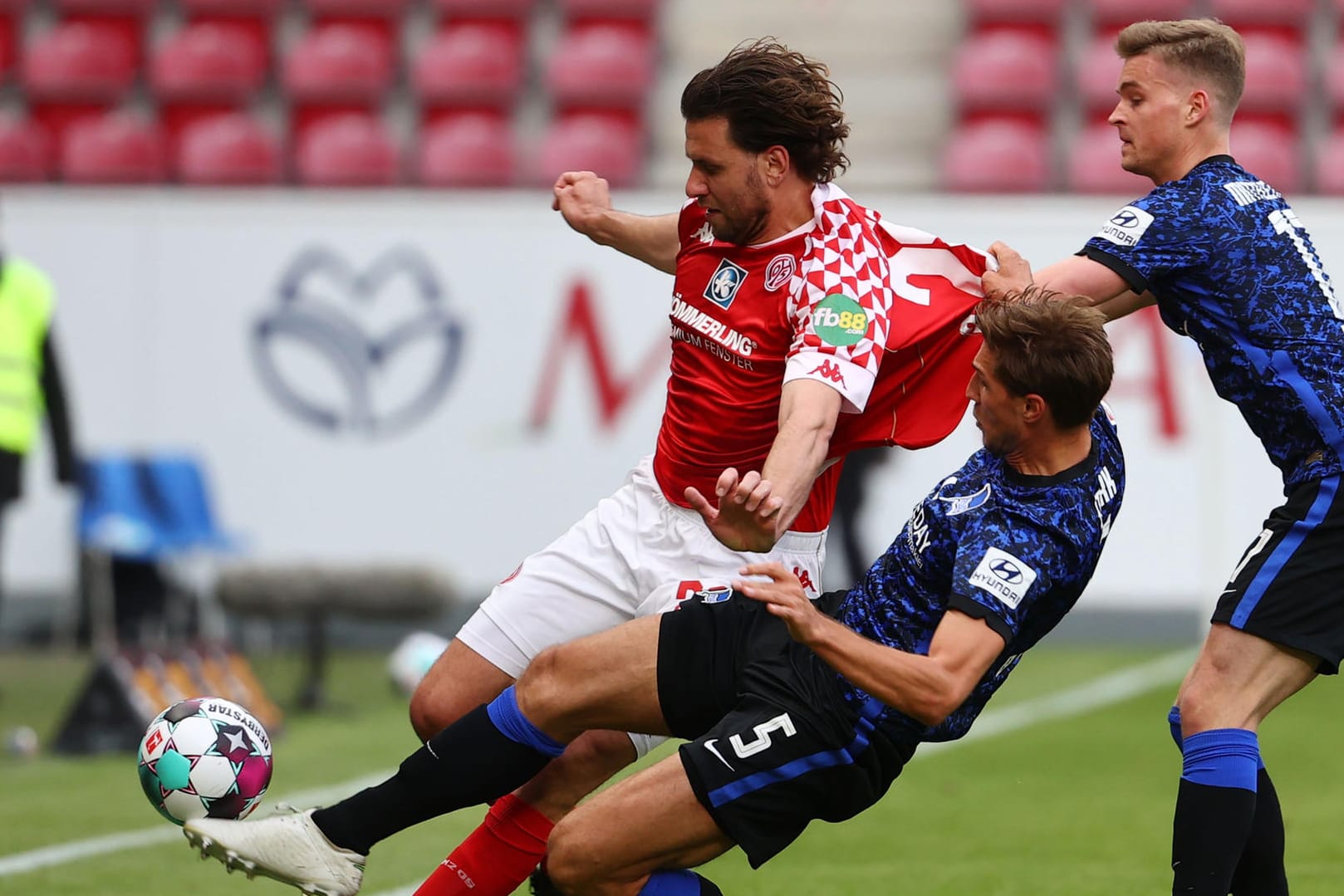 Grätschen, zerren, kämpfen: Die Herthaner Niklas Stark und Maximilian Mittelstädt (r.) versuchen Mainz-Stürmer Adam Szalai (l.) mit allen Mitteln zu stoppen.