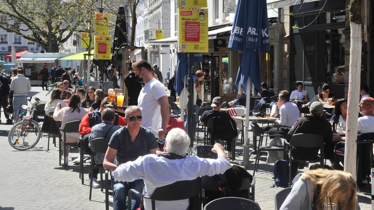 Menschen sitzen im April in Saarbrücken vor Cafés: Das Gastgewerbe fordert nun schnelle Öffnungsschritte.