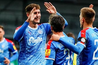 Die Kieler Phils Neumann (l-r), Fin Bartels und Hauke Wahl feiern den Treffer zum 1:0 gegen Sandhausen.