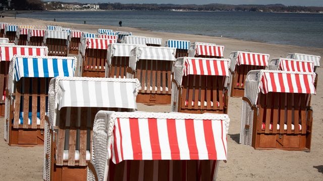 Geschlossene Strandkörbe stehen auf dem fast menschenleeren Strand in Timmendorfer Strand an der Ostsee. Geschlossene Strandkörbe stehen auf dem fast menschenleeren Strand in Timmendorfer Strand an der Ostsee.