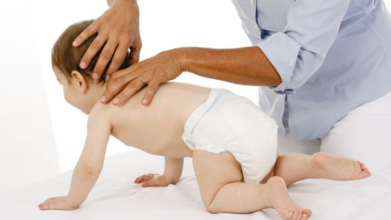 Eine Osteopathin behandelt ein Baby.