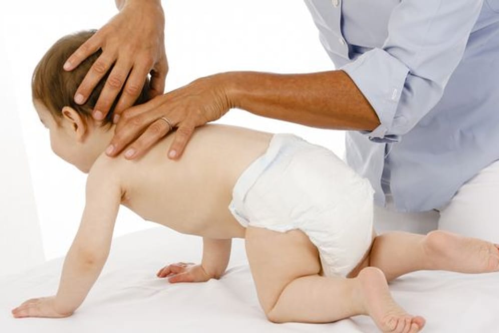 Eine Osteopathin behandelt ein Baby.