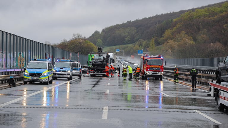 Rettungskräfte und ein Abschleppwagen stehen auf der A1 bei Wuppertal: Bei Hagel kam es zu mehreren Unfällen auf der Autobahn, die voll gesperrt wurde.