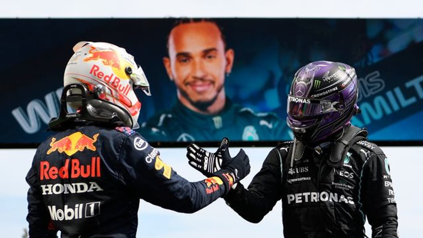 Der Brite Lewis Hamilton (r) vom Team Mercedes und der Niederländer Max Verstappen vom Team Red Bull Racing klatschen sich ab.
