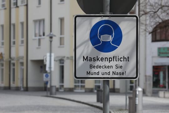 Ein Hinweisschild zur Maskenpflicht steht an der Fußgängerzone.