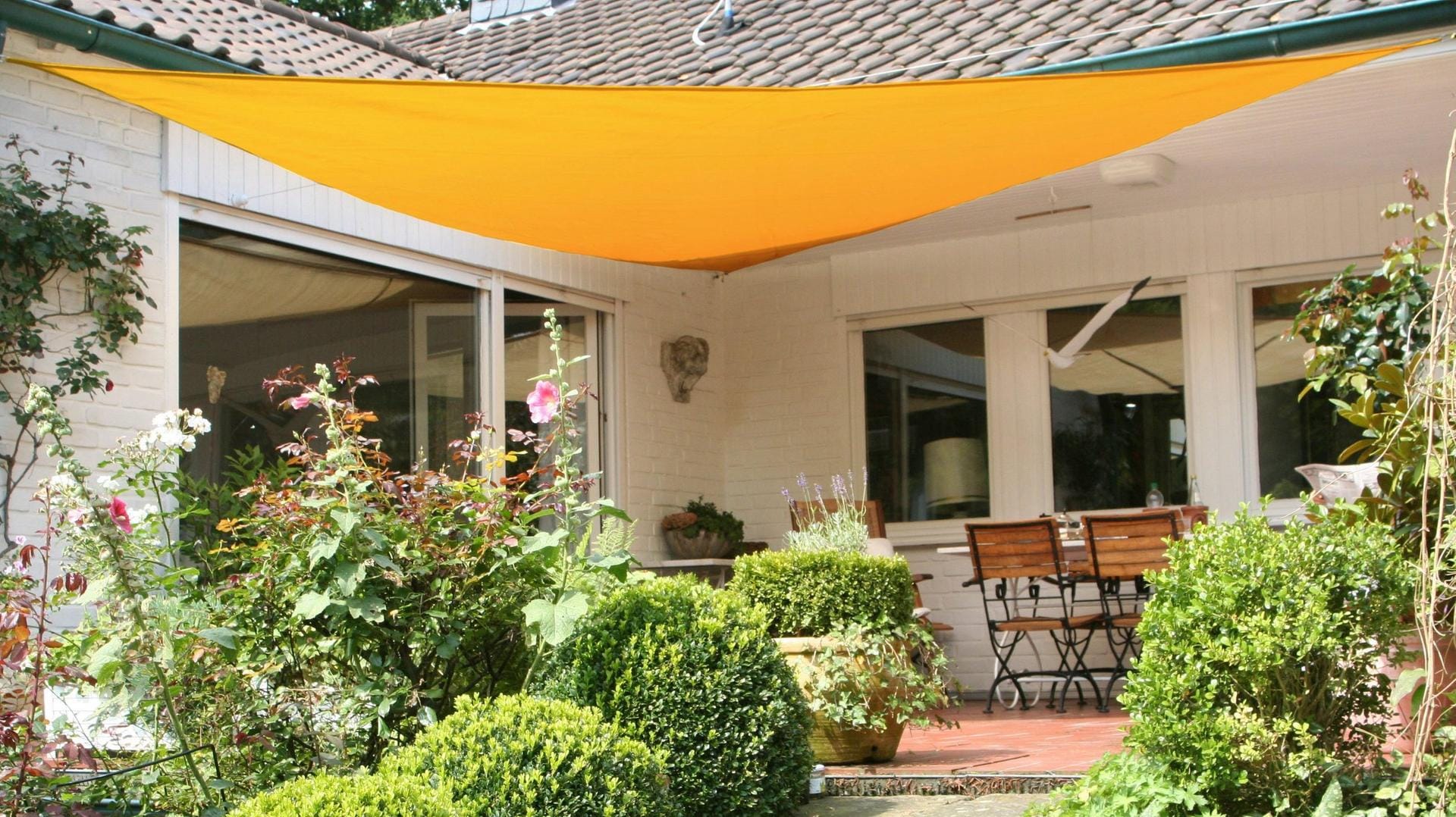 Wie in der Karibik: Ein Sonnensegel spendet Schatten auf Balkon und im Garten.