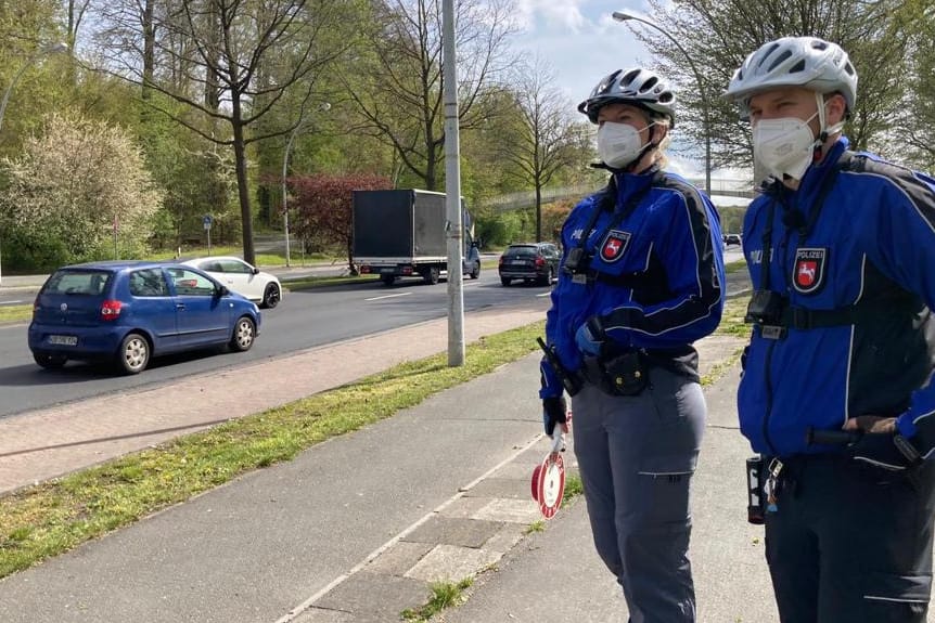 Zwei Polizeibeamte stehen am Straßenrand und tragen Fahrrradhelme und eine Maske: Bei der länderübergreifenden Aktion wurden viele Verstöße festgestellt.