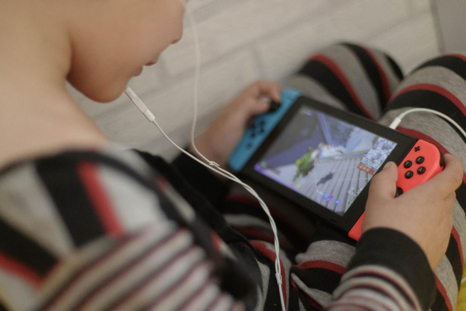 Ein 8-jähriger Junge spielt auf dem Bett ein Videospiel auf der Spielekonsole Switch: Der Erfolg der Spielekonsole Switch in der Corona-Pandemie hat Nintendo ein starkes Jahr beschert.