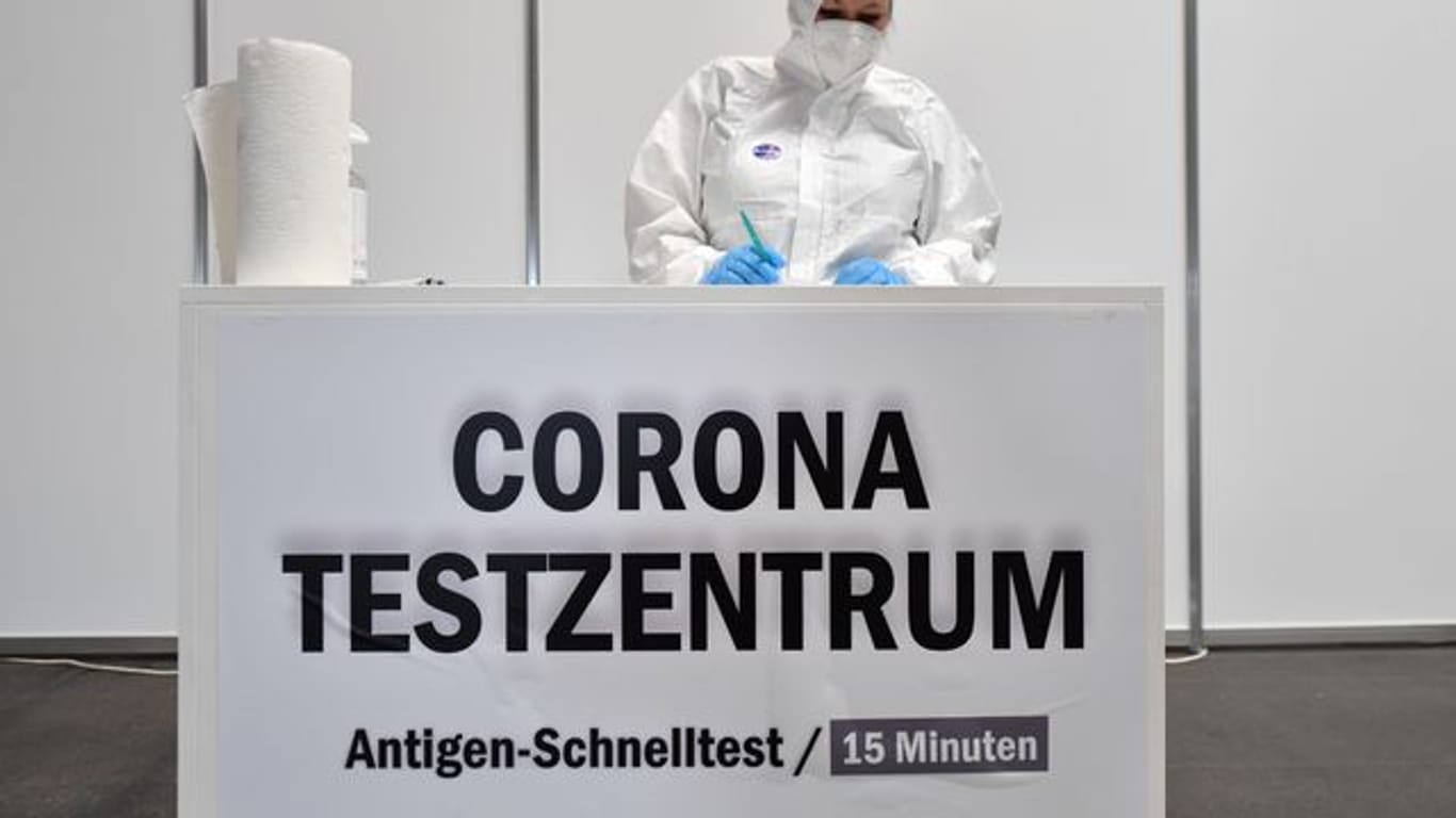 Eine Mitarbeiterin in Schutzkleidung steht im Corona-Testzentrum in der Messe Erfurt bereit.
