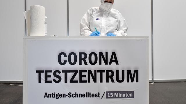 Eine Mitarbeiterin in Schutzkleidung steht im Corona-Testzentrum in der Messe Erfurt bereit. Eine Mitarbeiterin in Schutzkleidung steht im Corona-Testzentrum in der Messe Erfurt bereit.
