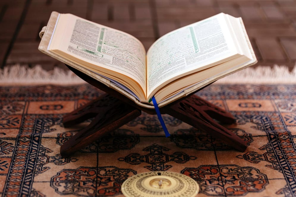 Ein aufgeschlagener Koran steht am Boden (Symbolbild): Statt in einer Moschee beten viele Muslime während der Pandemie zu Hause.