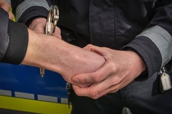 Ein Mann wird von einem Polizisten festgenommen (Symbolbild): In Stuttgart ist die Polizei auf zwei mutmaßliche Drogenhändler gestoßen.