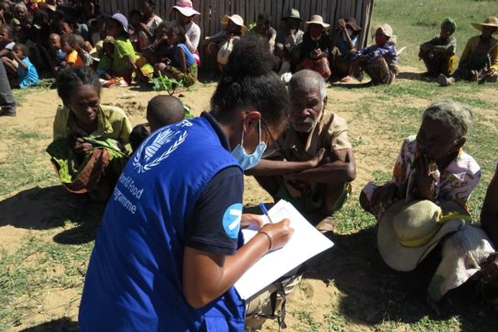 Eine Mitarbeiterin des Welternährungsprogramms spricht mit einigen Ältesten einer Gemeinde auf Madagaskar über ihre Situation.