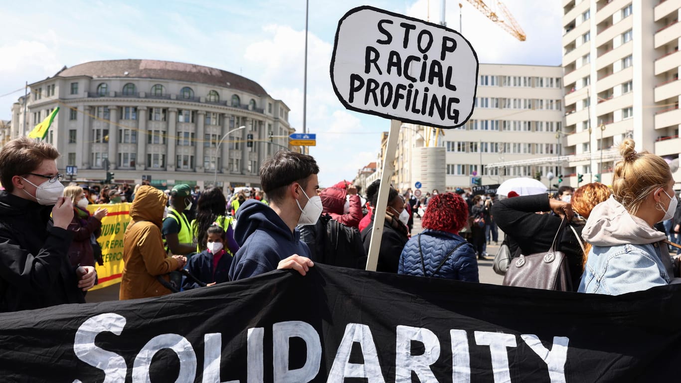 Teilnehmer der Demonstration halten ein Banner mit der Aufschrift "Solidarity" und ein Schild mit dem Schriftzug "Stop racial profiling": An dem Protestzug nahmen deutlich mehr Menschen teil als angemeldet.