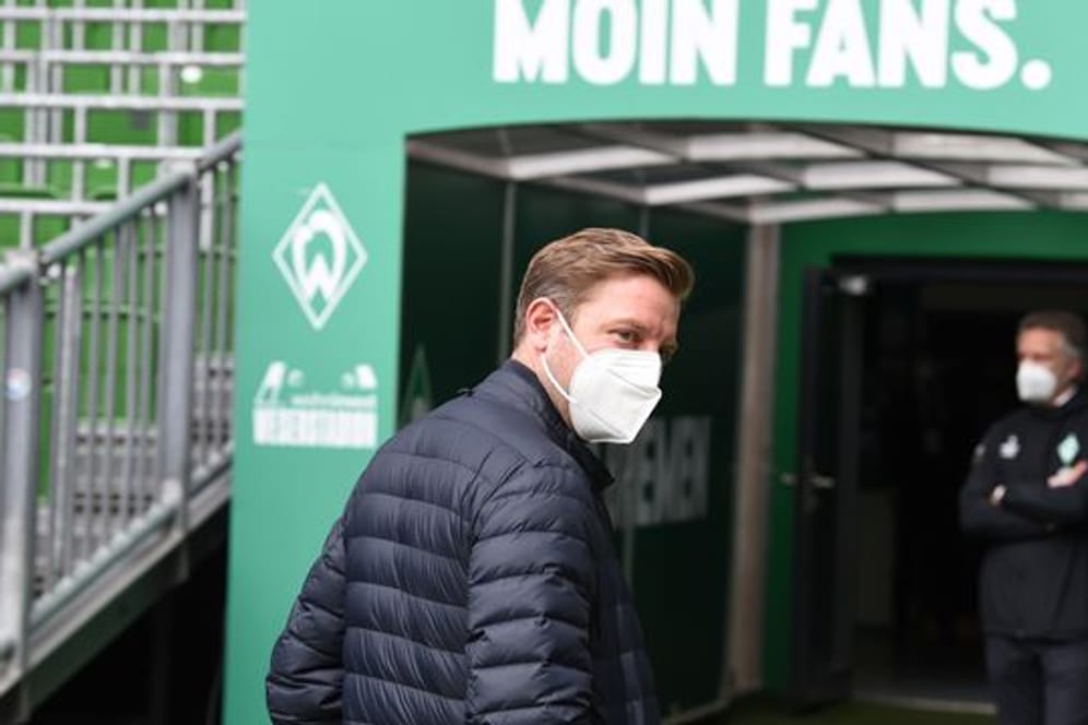 Werders Trainer Florian Kohfeldt (l) geht aus dem Innenraumbereich in die Kabine, im Hintergrund steht Geschäftsführer Frank Baumann.