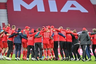Bayerns Spieler feiern nach Spielende die Deutsche Meisterschaft auf dem Rasen der leeren Allianz Arena.
