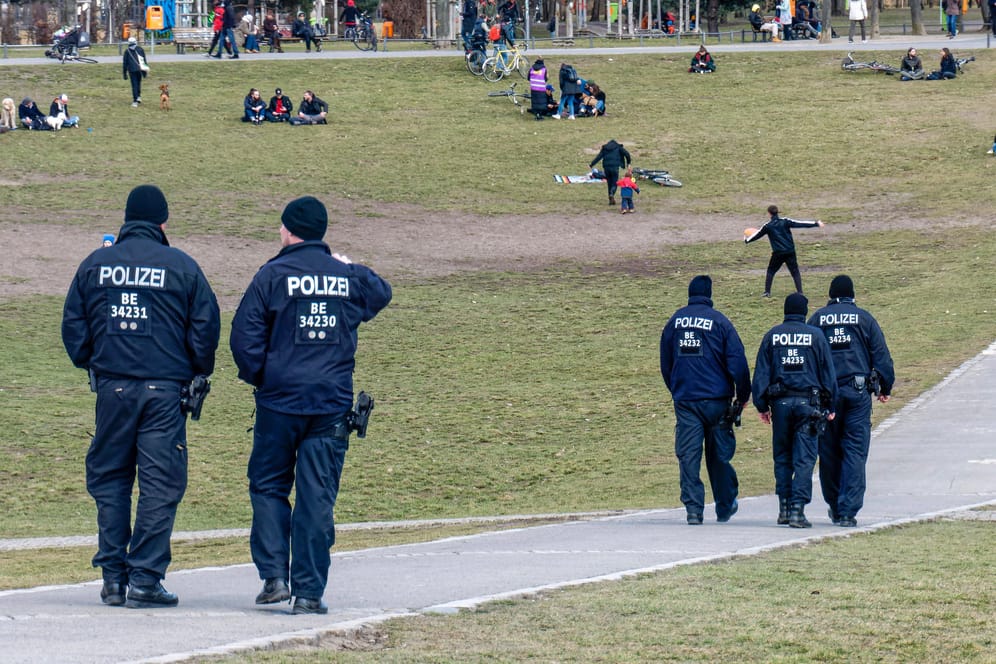 Polizisten gehen durch den Görlitzer Park: Hunderte Personen haben sich nicht an die Ausgangssperre gehalten und hielten sich auch nach 22 Uhr noch im Park auf.