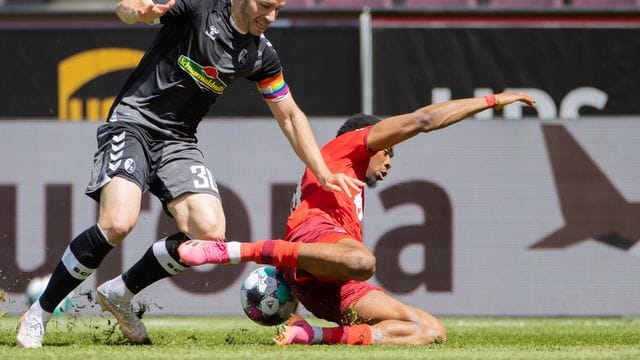 Der Kölner Kingsley Ehizibue (r) geht im Zweikampf mit Christian Günter zu Boden. Der Kölner Kingsley Ehizibue (r) geht im Zweikampf mit Christian Günter zu Boden.