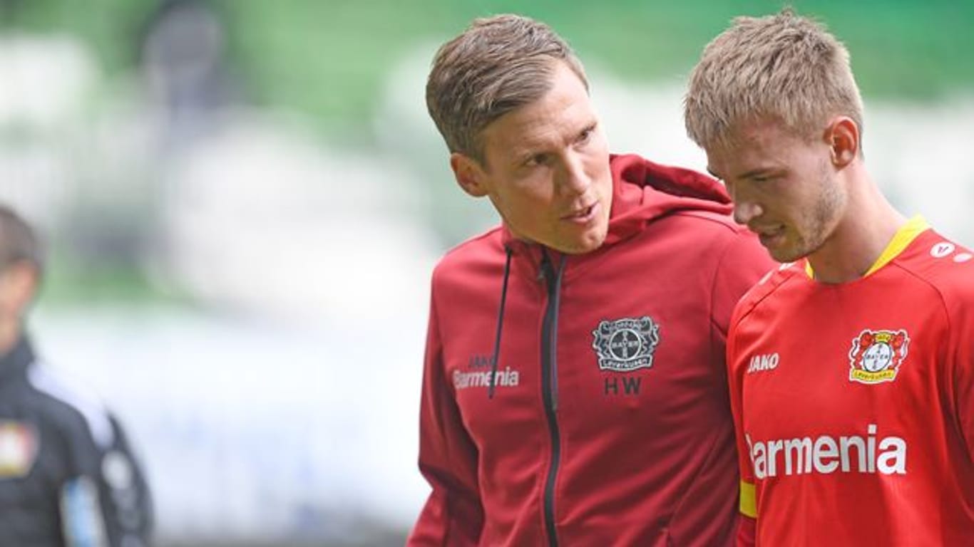 Leverkusens Trainer Hannes Wolf (l) spricht mit Daley Sinkgraven auf dem Weg in die Halbzeit.