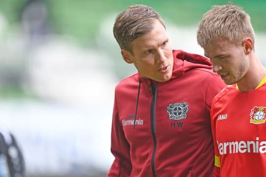 Leverkusens Trainer Hannes Wolf (l) spricht mit Daley Sinkgraven auf dem Weg in die Halbzeit.
