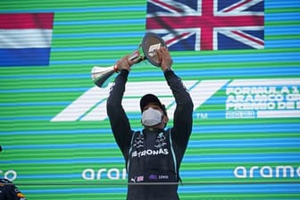Lewis Hamilton (r) bejubelt seinen Sieg auf dem Podium.