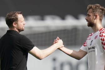 Mainz-Trainer Bo Svensson (l) klatscht nach dem Spiel mit Abwehrspieler Alexander Hack ab.