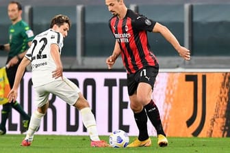 Juves Federico Chiesa (l) versucht Milans Zlatan Ibrahimovic vom Ball zu trennen.