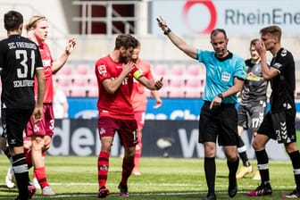 Jonas Hector vom FC Köln diskutiert mit Schiedsrichter Marco Fritz über das nicht gegebene Tor: Der FC hat wegen mehrerer Pannen gegen Freiburg verloren.