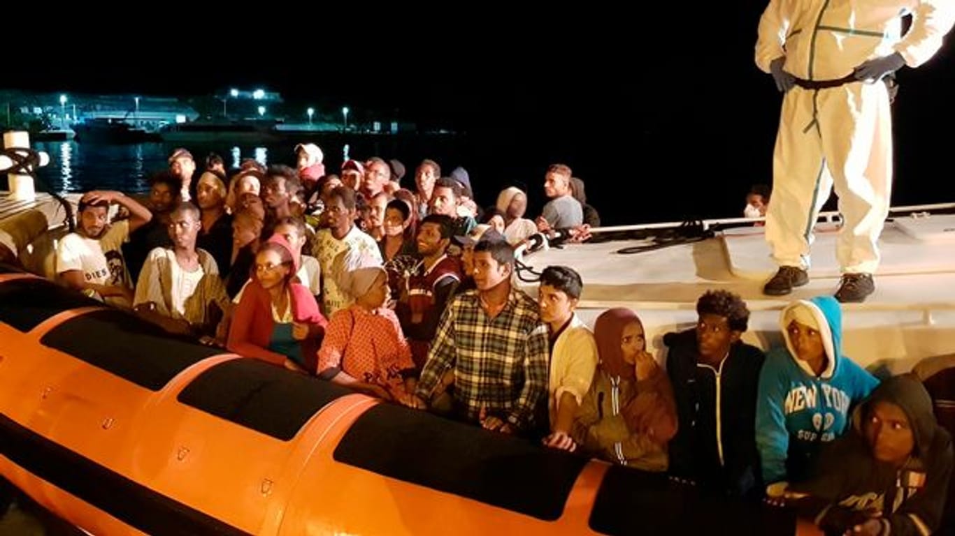 Flüchtlinge bereiten sich darauf vor, bei ihrer Ankunft im Hafen von Lampedusa aus einem Beiboot zu steigen (Archiv).