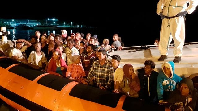 Flüchtlinge bereiten sich darauf vor, bei ihrer Ankunft im Hafen von Lampedusa aus einem Beiboot zu steigen (Archiv). Flüchtlinge bereiten sich darauf vor, bei ihrer Ankunft im Hafen von Lampedusa aus einem Beiboot zu steigen (Archiv).
