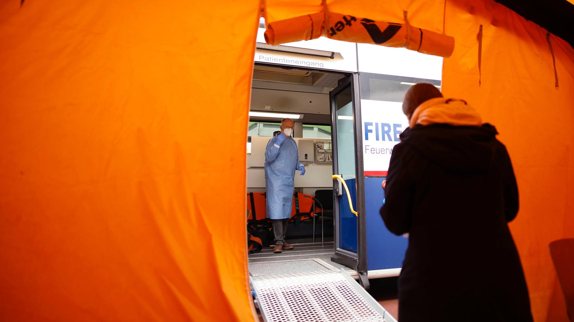 Eine Person auf dem Weg zum Impfbus: In Köln haben Sonderimpfungen in Hochinzidenz-Veedeln begonnen.