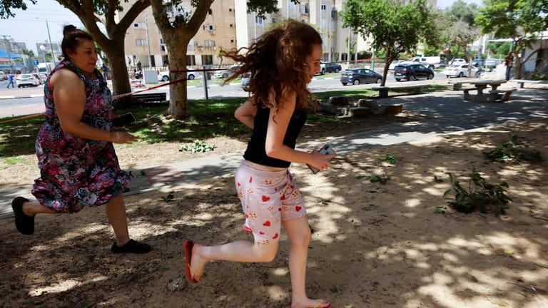 Szene aus Aschkelon in Israel: Eine Frau und ein Teenager fliehen im Moment des Raketenalarms.