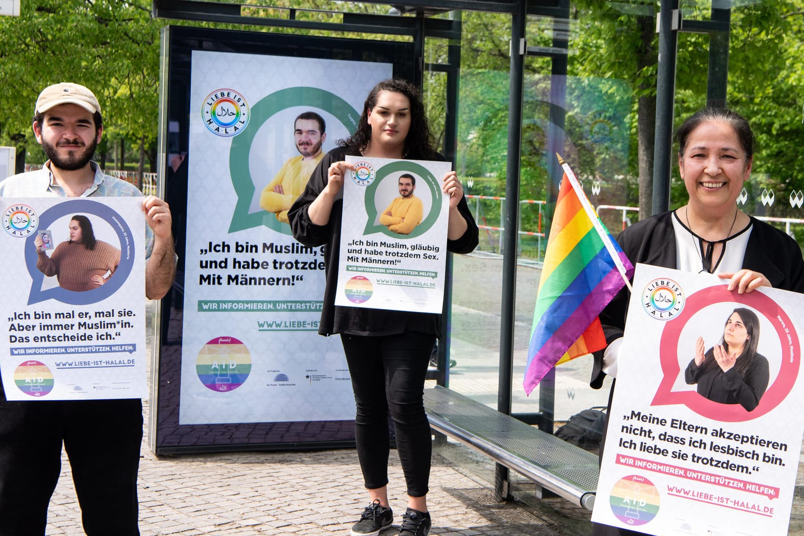 Seyran Ates (r.), geschäftsführende Gesellschafterin der Ibn Rushd-Goethe Moschee, mit den Models Tugay (l.) und Kweengypsy: Sie halten Plakate der Akzeptanzkampagne für queere Musliminnen und Muslime in der Hand.