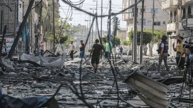 Palästinenser inspizieren das Umfeld des schwer beschädigten Al-Jawhara-Turm, nachdem der Turm von israelischen Luftangriffen getroffen worden war.