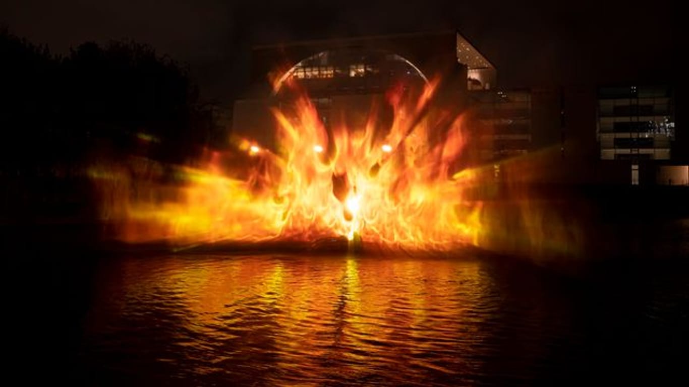 Flammen werden von der Spree aus auf das Bundeskanzleramt projiziert: Mit einem Hydro-Schild haben die Aktivisten das Feuer visualisiert.