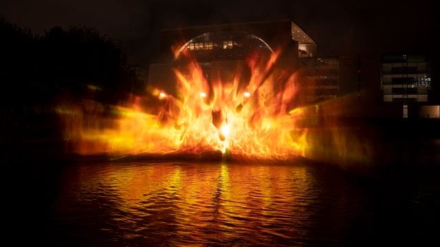 Flammen werden von der Spree aus auf das Bundeskanzleramt projiziert: Mit einem Hydro-Schild haben die Aktivisten das Feuer visualisiert.