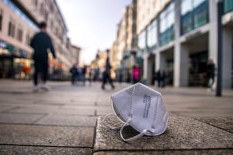 Eine Maske liegt in einer Fußgängerzone in Leipzig (Symbolbild): Die Maskenpflicht entfällt in der Fußgängerzone ab Freitag.