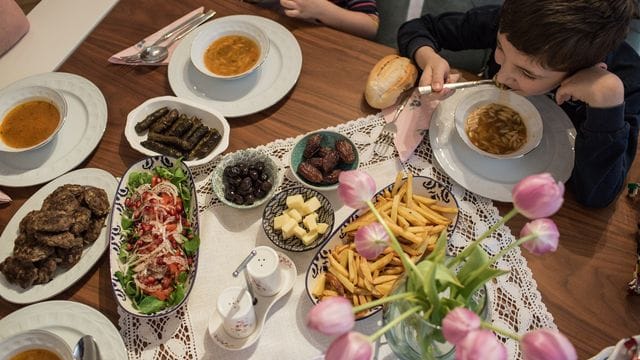 Kinder und Eltern nehmen während des heiligen Fastenmonats Ramadan ein gemeinsames Fastenbrechen-Essen in ihrer Wohnung ein.